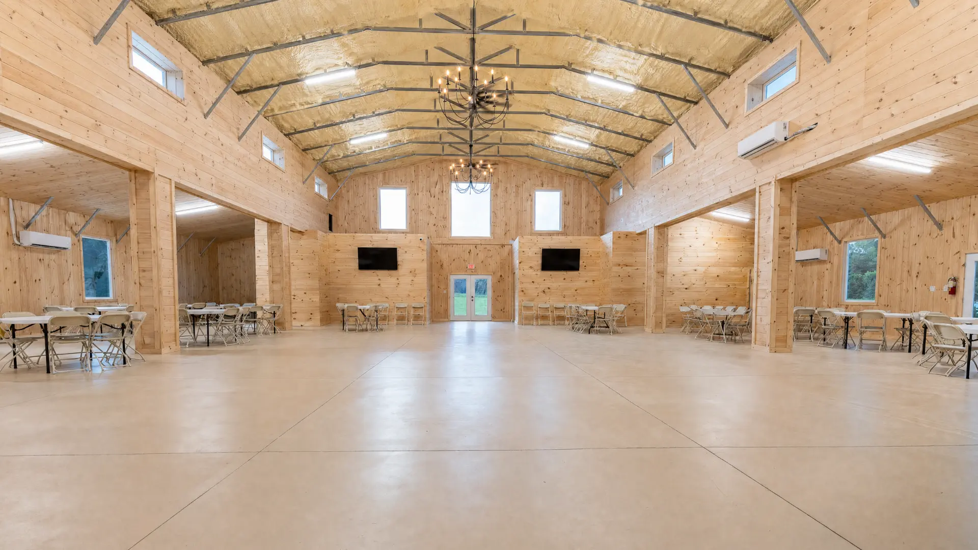 Event hall with iron chandeliers and vaulted pine ceiling